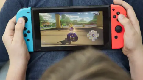 Getty Images. Хлопчик грає перемикач Nintendo